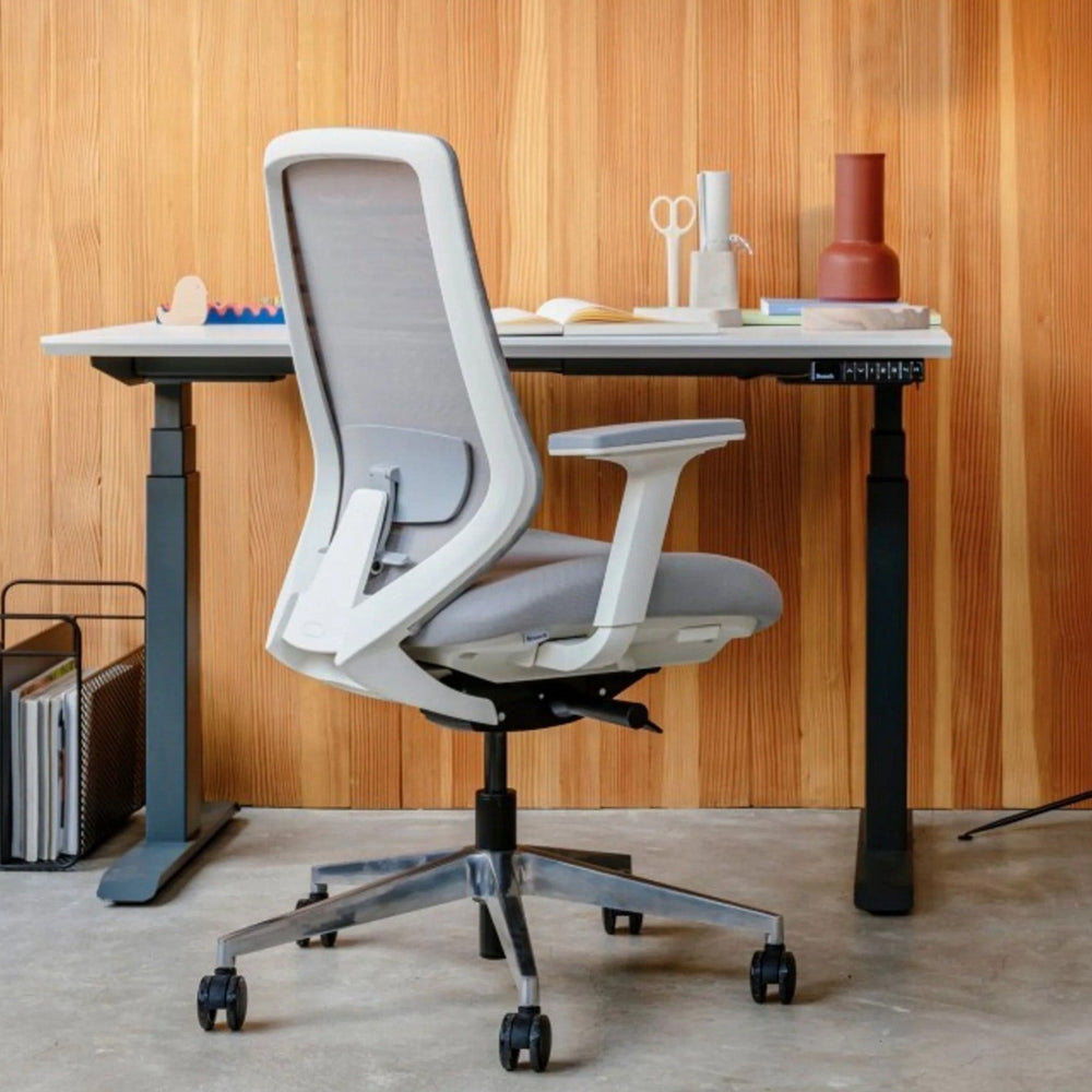 Model 11 white ergonomic office chair at adjustable desk, modern workspace setup